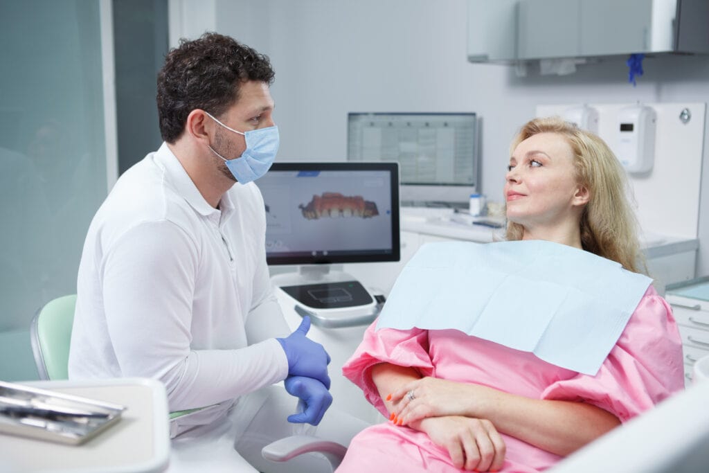 professional dentist treating teeth of patient